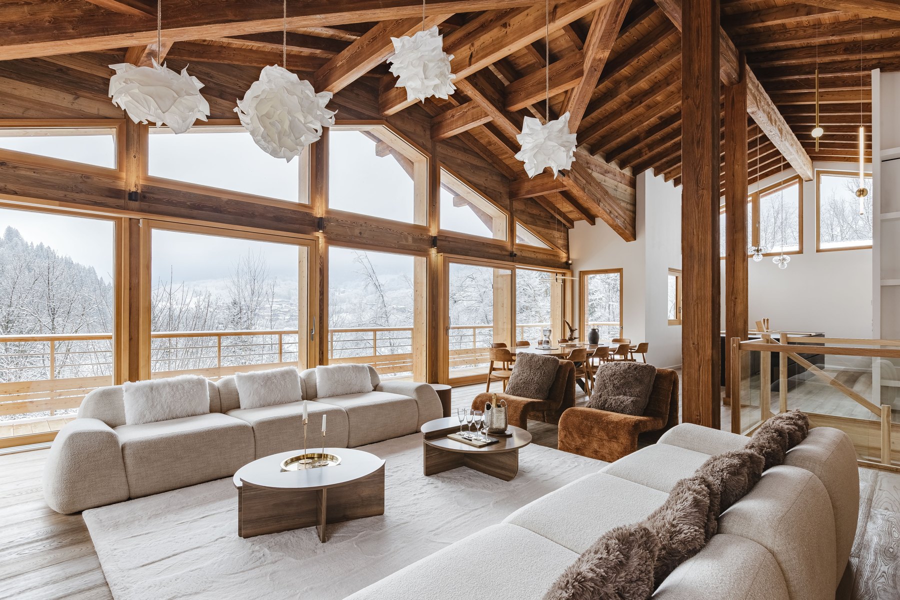 Le grand salon du chalet avec vue sur la forêt enneigée